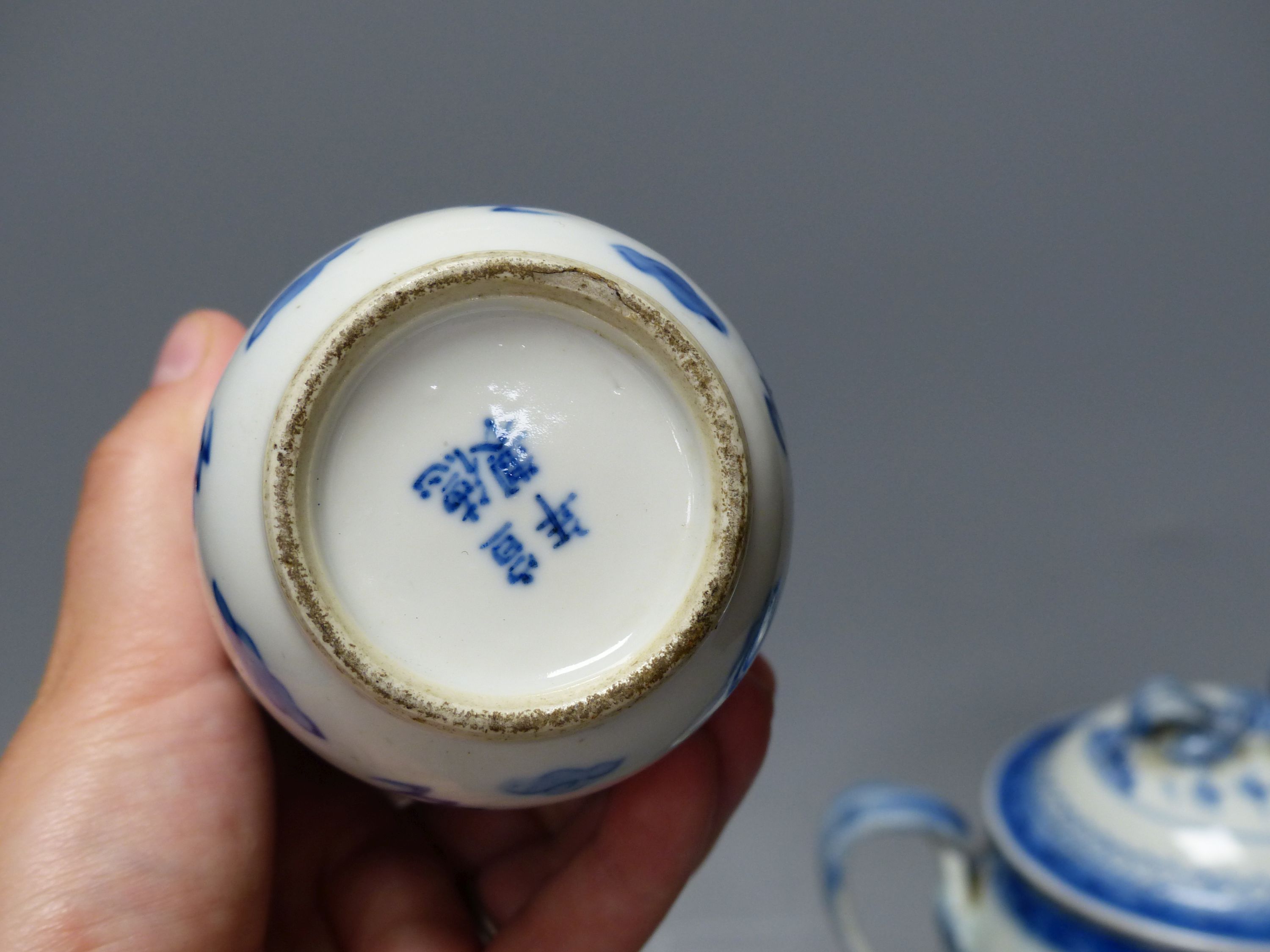 A 19th century Chinese blue and white covered jug, an early 20th century blue and white vase and a Kangxi rouge de fer teapot, tallest 18cm